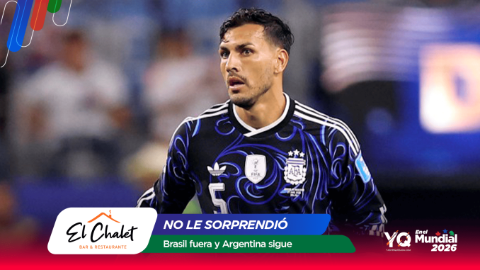 Soccer player in an Argentina national team jersey on the field with a blurred crowd behind and colorful sponsor graphics in the foreground.