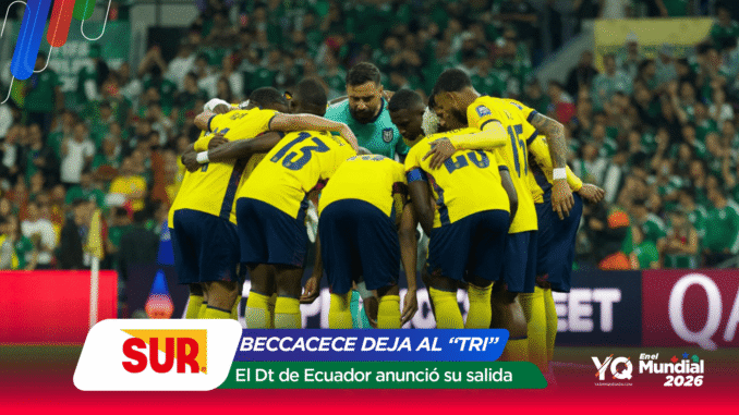 Football team in yellow uniforms huddle on the pitch around a teal-clad goalkeeper with a green stadium crowd behind them.