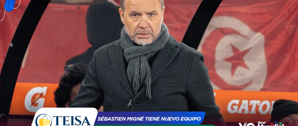 Man in a dark coat and gray scarf seated on a television sports set with red banners and sponsor logos in the background