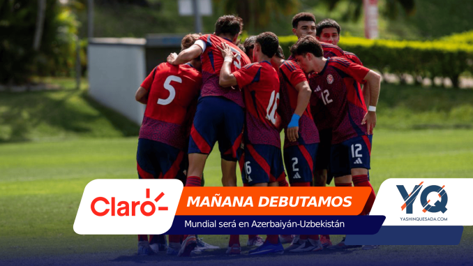 Group of soccer players in red uniforms huddling on a green field.