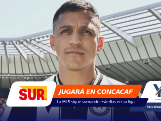Close-up portrait of a soccer player in a stadium with orange and navy promotional banners at the bottom framing the scene.