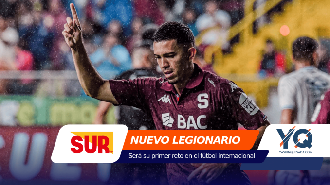 Soccer player in a maroon jersey raises one finger in celebration on a rainy stadium, with colorful sponsor banners at the bottom reading NUEVO LEGIONARIO and related logos in view.