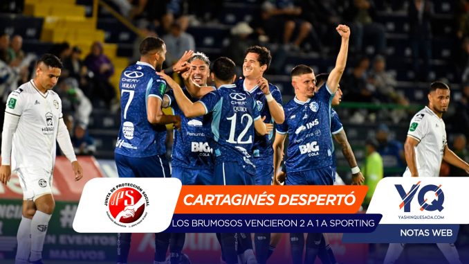 Soccer players in blue celebrate a goal while a few white-uniformed players look on in a stadium banner with text overlays at the bottom of the image.