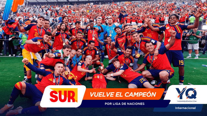 Soccer team in red jerseys posing with medals and a trophy after winning, as cheering fans fill the stands behind them.