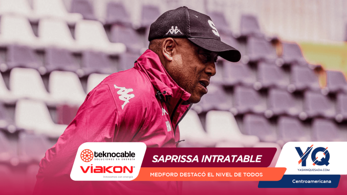 Profile of a man in a pink jacket and cap at a bleacher-filled stadium, with sponsor banners across the bottom indicating a promotional event.